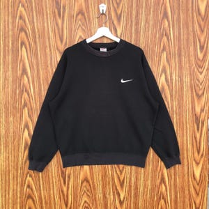 May include: A white ceramic mug with a black handle and the text "But First, Coffee" in a handwritten style. The mug is on a white surface. The mug is approximately 4 inches tall.