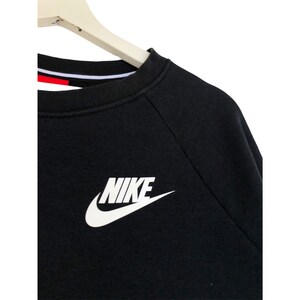 May include: Black long-sleeve sweatshirt with a white Nike logo on the front.