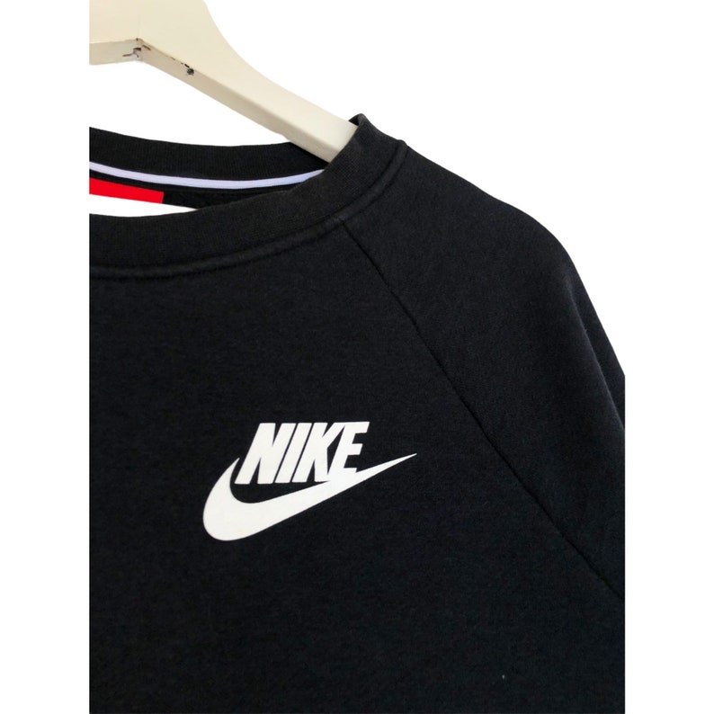 May include: Black long-sleeve sweatshirt with a white Nike logo on the front.