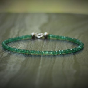 Puede incluir: Un delicado brazalete de piedras preciosas verdes con un cierre de plata. El brazalete está hecho de pequeñas piedras preciosas facetadas y es perfecto para el uso diario.