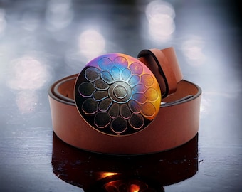 May include: A brown leather belt with a large, round, iridescent buckle featuring a stylized flower design.