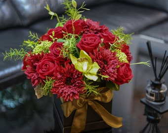 Ein roter Blumenstrauß in einer Schachtel-Seidenrote Rosen in Schwarzer Box