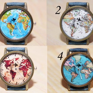May include: Four wristwatches with different world map designs. Each watch has a denim blue strap and a gold-toned case. The maps are in different colour schemes, including blue, white, red, and green.