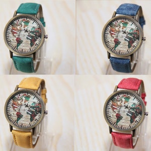 May include: Four wristwatches with different colored bands. Each watch has a round face with a world map design and a bronze-colored case.