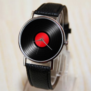May include: A black leather wristwatch with a silver case and a black and red vinyl record design on the face.