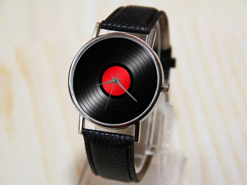 May include: A black leather wristwatch with a silver case and a black and red vinyl record design on the face.