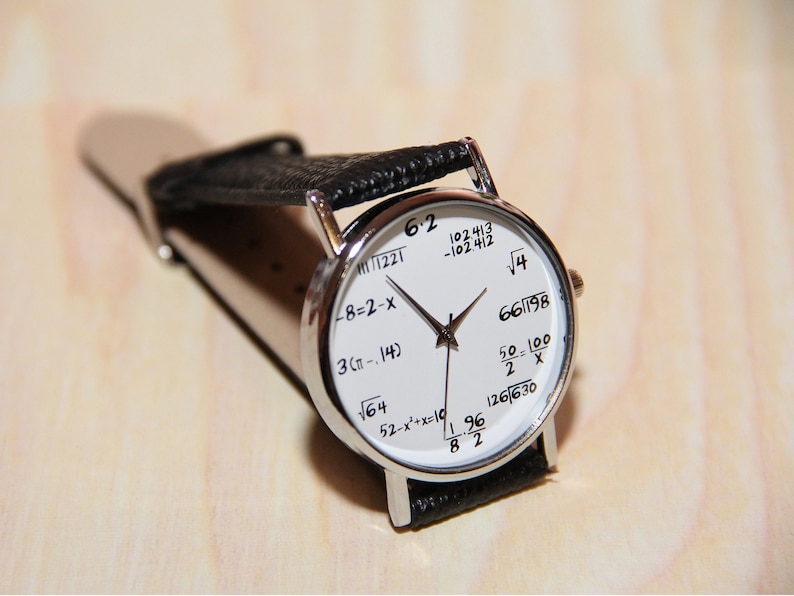 May include: A silver wristwatch with a white face and black leather band. The face of the watch features various mathematical equations and numbers, including 6.2, 102413, -102412, &radic;4, 66/198, 50-100/2 x, 52-x&sup2;+x=10, 126/630, 196/82, -8-2-x, 3(&pi;-.14), and &radic;164.