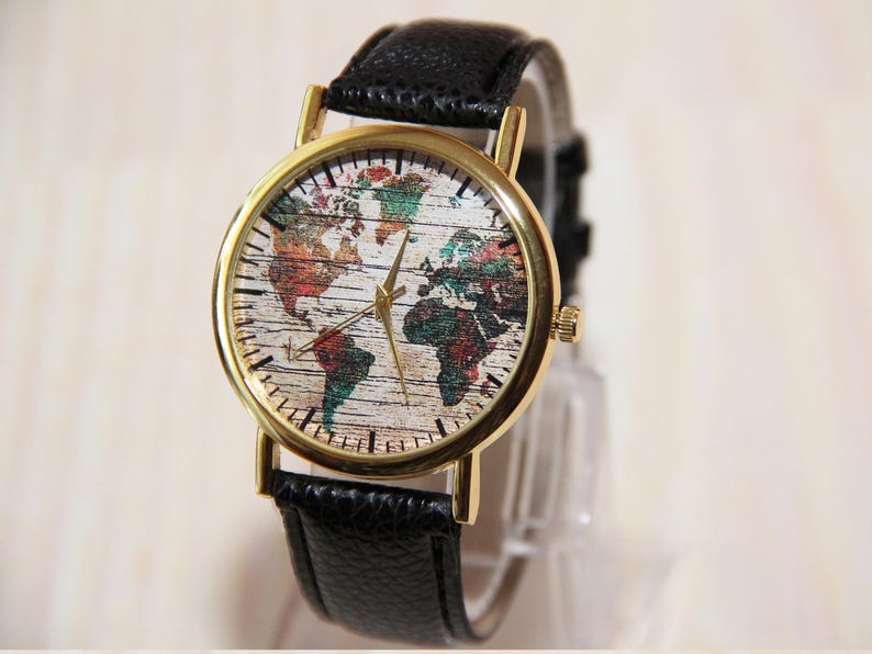 May include: A gold-tone wristwatch with a black leather band. The watch face features a colorful world map design.