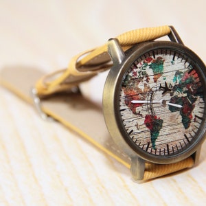 May include: A vintage-style wristwatch with a brown leather band and a round face featuring a colorful world map design.