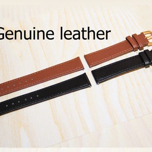 Puede incluir: Dos correas de reloj de cuero genuino, una marr&oacute;n y otra negra, con hebillas doradas. Cuero genuino.