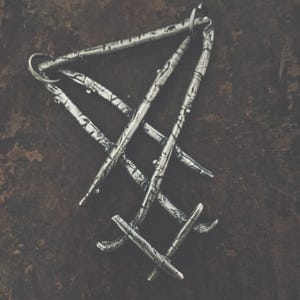 May include: A silver pendant in the shape of a triangle with a textured surface. The pendant is made of multiple interwoven metal strips.