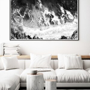 Puede incluir: Fotograf&iacute;a en blanco y negro de olas rompiendo en el oc&eacute;ano. La imagen est&aacute; tomada desde una perspectiva a&eacute;rea, mostrando la espuma blanca de las olas contra el agua oscura.