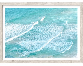 May include: An aerial view of turquoise ocean water with white foamy waves crashing in rows.