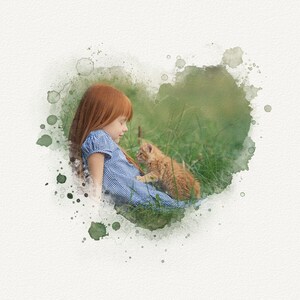 May include: A young girl with red hair sits in a field of green grass, looking down at a small orange kitten. The image is framed with a watercolor heart shape.