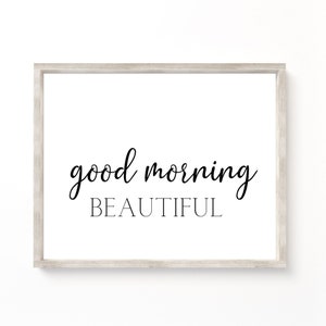 Puede incluir: Una impresión enmarcada con el texto "good morning beautiful" en fuente cursiva negra sobre un fondo blanco.