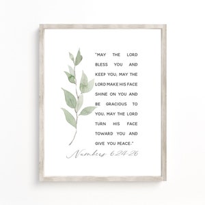 May include: A framed print with a light wood grain border. The print features a watercolor illustration of green leaves and text from Numbers 6:24-26 in a delicate script. The text is in black and the background is white.