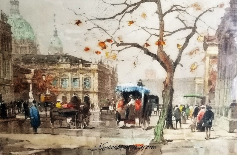 Op de afbeelding: Een aquarel schilderij dat een stadssc&egrave;ne met een koets getrokken door paarden, mensen die lopen en gebouwen op de achtergrond laat zien. De sc&egrave;ne speelt zich af in een Europese stad, met een groot gebouw op de achtergrond en een boom met oranje bladeren op de voorgrond.