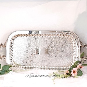 May include: A white ceramic mug with a black handle and the text "But First, Coffee" in a black, handwritten-style font. The mug is on a white surface.