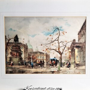 Op de afbeelding: Een aquarel schilderij dat een stadstraat sc&egrave;ne voorstelt met een standbeeld op de voorgrond, gebouwen op de achtergrond en mensen die over straat lopen. De lucht is bewolkt en de gebouwen zijn geschilderd in tinten grijs en bruin.