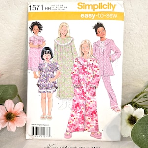 May include: A Simplicity 1571 sewing pattern envelope for children's sleepwear in sizes 3-6. The cover features illustrations of five different pajama and robe styles with floral and patterned fabrics in pink, green, and purple color schemes.