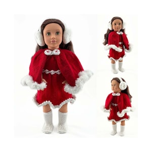 May include: A doll wearing a red knitted dress and cape with white faux fur trim. The doll also has white earmuffs and matching white knitted socks and boots. The doll has brown hair and is on a white background.