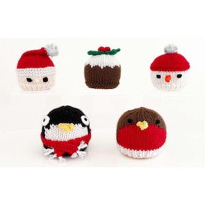Op de afbeelding: Een verzameling van vijf gebreide kerstversieringen. De ornamenten omvatten een kerstman, een sneeuwpop, een kerstpudding, een pinguïn en een roodborstje. Elk ornament is gemaakt van garen en heeft een uniek ontwerp en kleurenschema.
