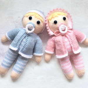 Twin dolls knitting pattern 9 inches tall. Baby girl has pink and white striped body, pink jacket, pink bonnet and pacifier. Baby boy has blue and white striped body, blue jacket, blue beanie and pacifier. Legs, body and head worked all in one.