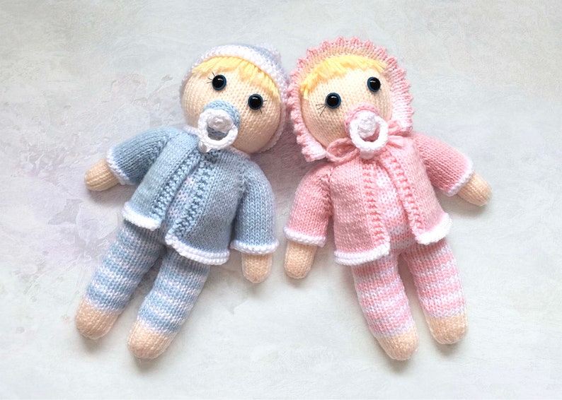 Twin dolls knitting pattern 9 inches tall. Baby girl has pink and white striped body, pink jacket, pink bonnet and pacifier. Baby boy has blue and white striped body, blue jacket, blue beanie and pacifier. Legs, body and head worked all in one.