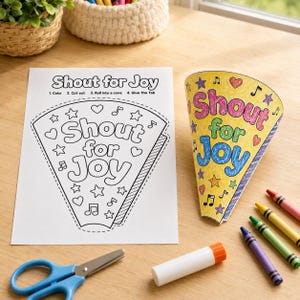 May include: A white paper sheet with the black text Shout for Joy and instructions for a craft project, alongside a finished yellow cone with the same text in pink, green, and blue, plus blue scissors, a glue stick, and four crayons.