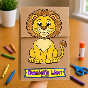 May include: A brown paper bag featuring a colorful hand-drawn illustration of a lion with a yellow body and brown mane. Below the lion, a blue banner contains the purple text "Daniel's Lion" and the smaller black text "Daniel 6:22".