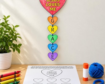 May include: A hanging mobile featuring a large red heart with the text JESUS LOVES ME, connected to five smaller hearts in orange, yellow, green, blue, and purple, each displaying a letter to spell GRACE, alongside a printed craft template.