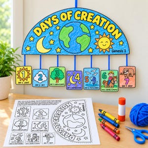May include: A Days of Creation mobile craft kit featuring a semi-circular header with a globe, sun, and moon, and seven hanging rectangular cards numbered one through seven. Below, a printed activity sheet, glue stick, crayons, and blue yarn.