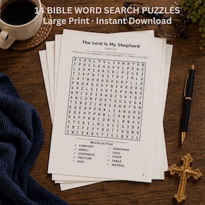 May include: A stack of Bible word search puzzles with the text "14 BIBLE WORD SEARCH PUZZLES Large Print Instant Download." The puzzles are on white paper with a black pen, a gold cross, and a cup of coffee on a wooden surface.