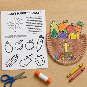 May include: A craft activity sheet titled GOD'S HARVEST BASKET with instructions and fruit outlines, alongside a finished paper plate basket colored brown with a yellow cross and colorful fruit cutouts, blue scissors, a glue stick, and two crayons.
