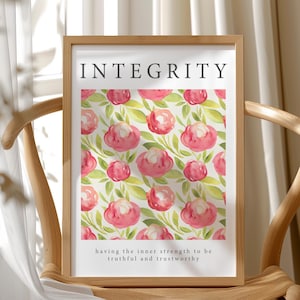 Op de afbeelding: Een ingelijste print met het woord "INTEGRITY" bovenaan. De print toont een patroon van roze aquarelbloemen en groene bladeren. De onderkant van de print luidt: "de innerlijke kracht hebben om waarheidsgetrouw en betrouwbaar te zijn."