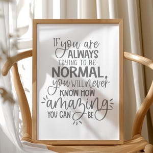 May include: A framed print with the quote "If you are always trying to be normal, you will never know how amazing you can be." The text is in a mix of fonts and sizes, set against a white background, and framed in light wood.