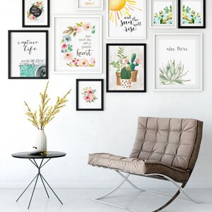 May include: A gallery wall featuring framed art prints with floral, botanical, and inspirational themes. The prints include watercolor illustrations of flowers, cacti, and a sun, along with uplifting quotes like "Capture Life" and "Start each day with a grateful heart."