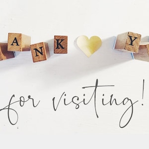 May include: A set of wooden blocks arranged to spell the words THANK YOU with a small wooden heart shape between the words. Below the blocks, the text for visiting! is written in a dark, cursive script font on a plain white background.