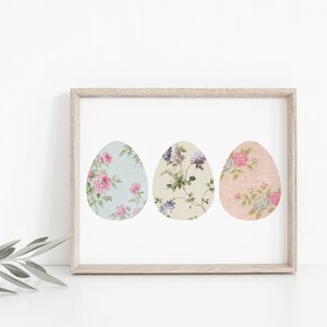 May include: A framed print of three pastel-colored Easter eggs with floral patterns. The eggs are arranged horizontally in a row.
