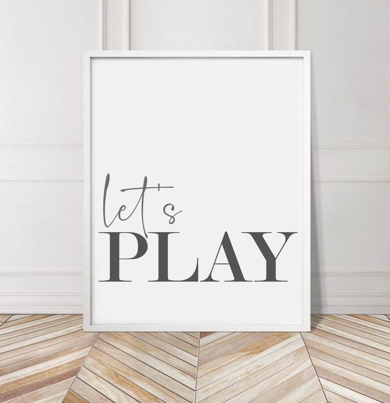 May include: A white framed print with the text "let's PLAY" in gray lettering on a white background.