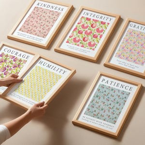 May include: Six framed art prints with inspirational words: Kindness, Integrity, Gratitude, Courage, Humility, and Patience. Each print features a floral pattern in various colors, set in a light wood frame. The prints are displayed on a neutral-toned surface.