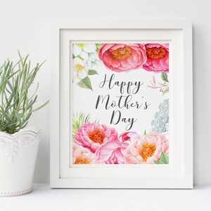 May include: White framed print with watercolor flowers in shades of pink, white, and green. The text "Happy Mother's Day" is written in black cursive.