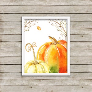 May include: Watercolor painting of pumpkins in shades of yellow, orange, and green. The pumpkins are arranged in a group, with a white frame and a background of bare branches and leaves. The artwork is a fall-themed print.