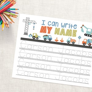 May include: A printable worksheet with a construction theme for children to practise writing their name. The worksheet features a construction crane, dump trucks, and cones. The text "I can write my name" is at the top of the page. The names "Carson" and "Jacobs" are written in dotted lines for tracing.