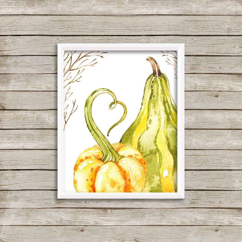 Peut inclure: Peinture &agrave; l'aquarelle de deux citrouilles dans un cadre blanc. L'une est jaune et orange, l'autre verte et jaune. La tige de la citrouille jaune forme un c&oelig;ur. Fond blanc avec des branches brunes.
