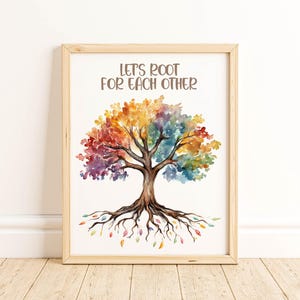 May include: Watercolor art print of a tree with a rainbow-colored canopy and brown trunk and roots. The text "LET'S ROOT FOR EACH OTHER" is at the top. The artwork is in a light wood frame.