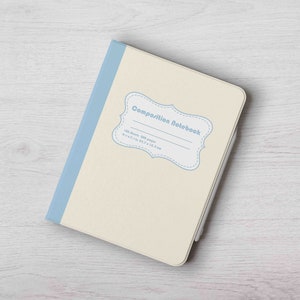 Könnte beinhalten: Ein cremefarbenes Kompositionsheft mit einem blauen Rücken und einem blauen Etikett mit der Aufschrift "Composition Notebook" mit den Details "100 Blatt, 80g Papier, 21x14,8 cm, 8,3x5,8 Zoll".