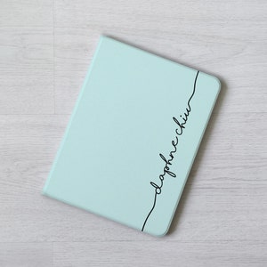 May include: A light blue notebook with the word "daphne chin" written in black cursive on the cover.