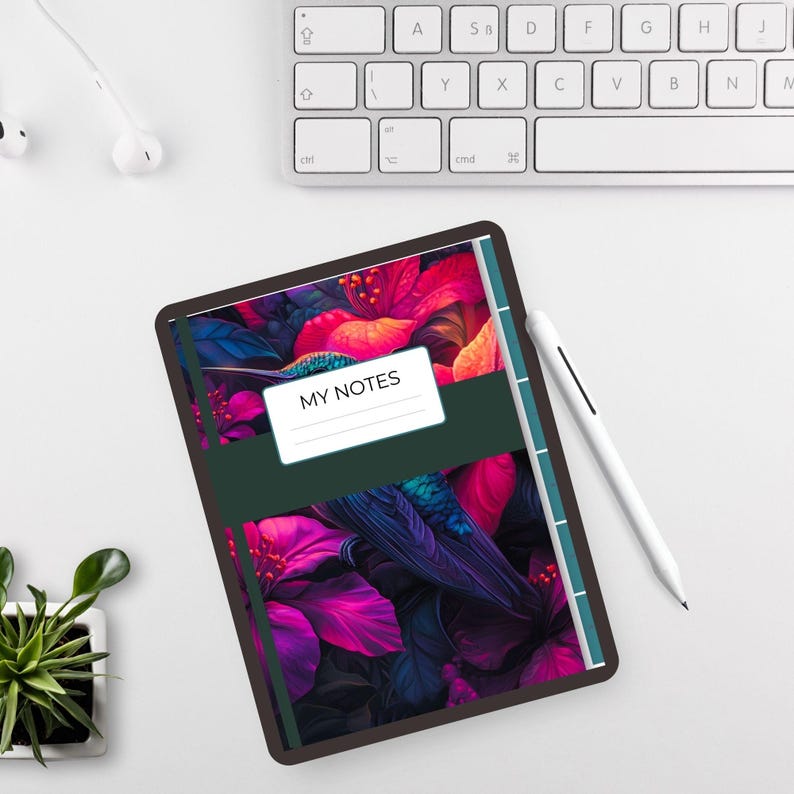 以下が含まれることがあります： ピンク、赤、青の花柄のデジタルタブレット。タブレットには、白いラベルに「MY NOTES」というテキストが入った濃い緑色のバンドが付いています。白いスタイラスとキーボードも表示されています。