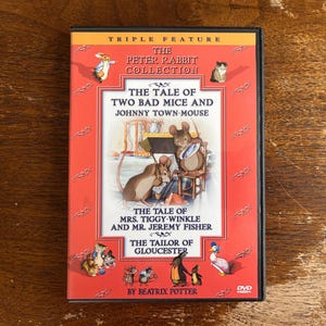 May include: A DVD case featuring "The Peter Rabbit Collection" with illustrations of animals and the titles "The Tale of Two Bad Mice and Johnny Town-Mouse", "The Tale of Mrs. Tiggy-Winkle and Mr. Jeremy Fisher", and "The Tailor of Gloucester".